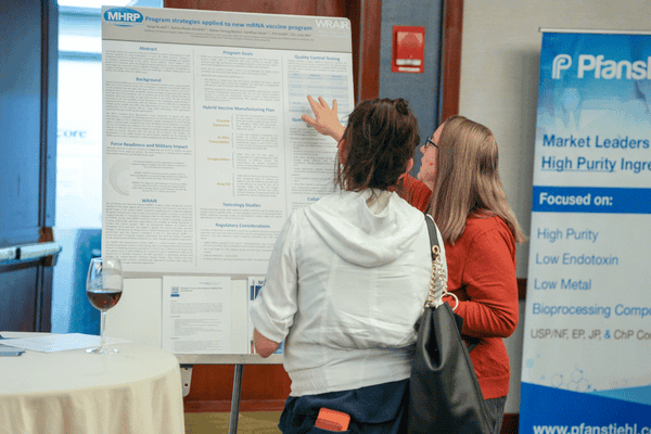Attendees reviewing scientific poster on SaRNA, Circular RNA and advanced RNA therapeutics